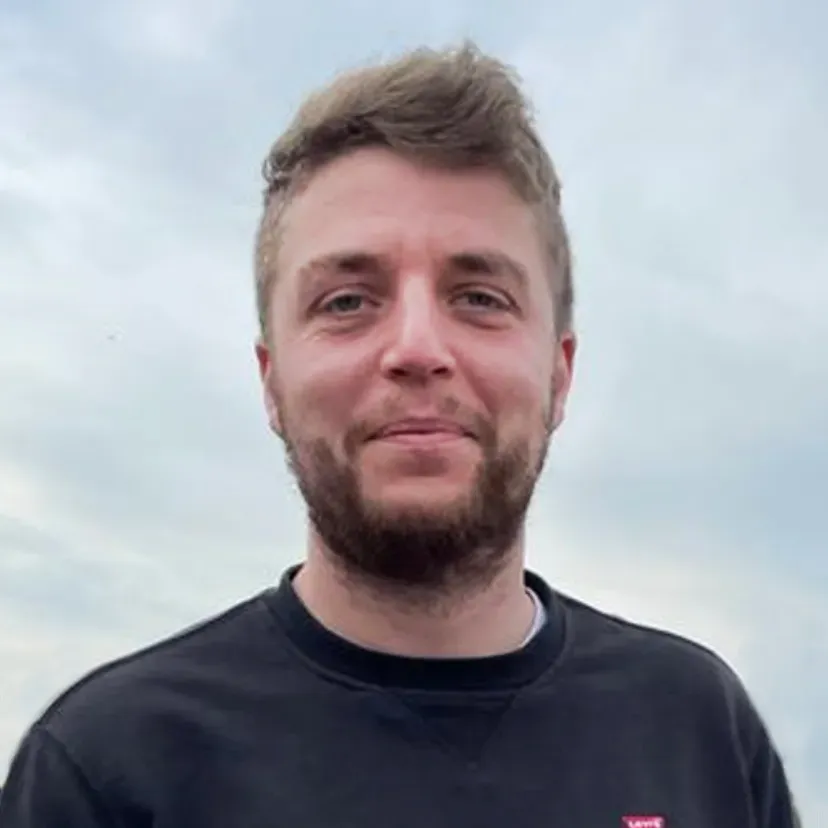 Jonas Hansen im Profilbild. Er hat kurze blonde Haare, trägt Bart und hat einen schwarzen Pullover an. 